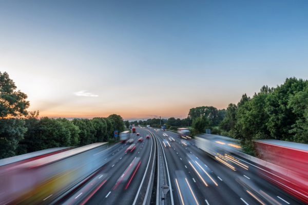 Sunset view heavy traffic moving at speed on UK motorway in England.
